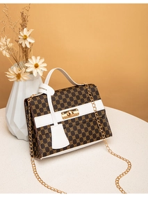 Detailed close-up of floral print handbag with white leather trim and gold twist lock