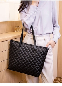 Close-up of black quilted tote bag showing leather texture and elegant stitching