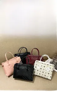 Close-up of leather handbags featuring V-shaped stitching and floral embossed patterns