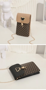Close-up of geometric pattern texture and metal character clasp on the crossbody bag