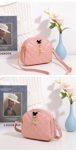 Détail du sac à bandoulière rose matelassé demi-lune avec breloque étoile dorée chic