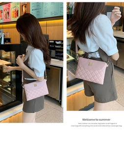 Detailed side view of pink quilted mini bag with golden chain and embroidery patterns