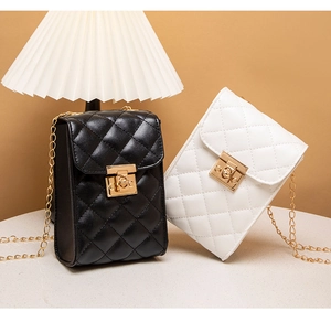 Close-up of quilted chain bags in black and white with gold locks and metal straps
