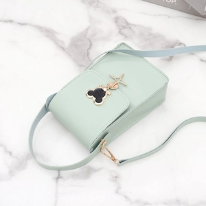 Mint green mini crossbody bag featuring black Mickey-shaped emblem and adjustable strap