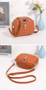 Détail d'un sac bandoulière marron matelassé en forme de coquille avec logo Mickey en métal
