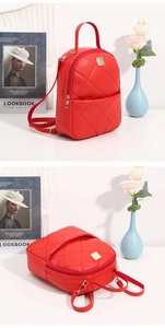 Detail of red quilted PU leather mini backpack with gold hardware and adjustable straps