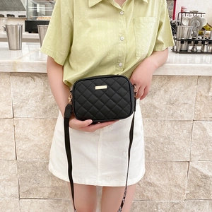 Women's black quilted crossbody bag with embroidered strap and gold hardware accents