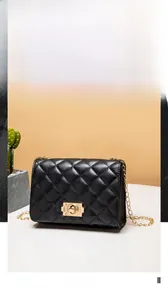 Detail of black quilted chain bag with gold metal rotary buckle and luxury texture