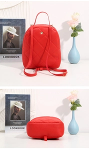 Detail of red quilted backpack showing back structure and adjustable shoulder straps