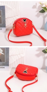 Détail du sac bandoulière demi-rond rouge matelassé avec pendentif Mickey doré et cuir PU