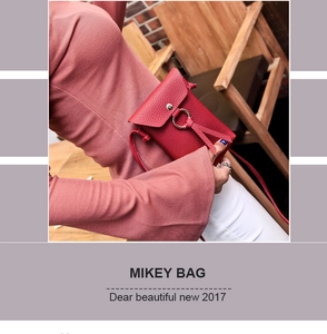 Detail of red litchi texture crossbody phone bag with gold circular buckle and long strap