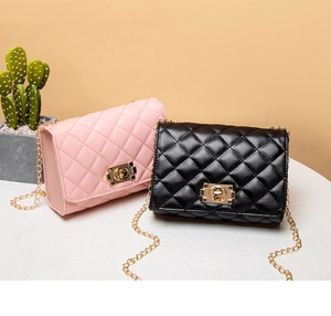 Detail of pink and black quilted shoulder bags with gold chain straps and metal locks