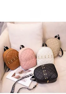 Detailed shot of quilted mini backpacks with gold studs and lettered straps in five colors