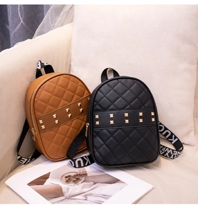 Close-up of quilted PU leather mini backpacks with gold studs and lettered canvas straps