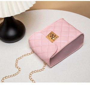 Detail of pink quilted camera bag featuring golden twist lock and elegant chain strap