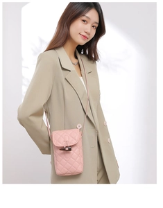 Detailed view of pink quilted crossbody phone bag with classic toggle closure on model