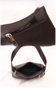 Detail of dark brown quilted shoulder bag showing back zipper pocket and main compartment