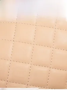 Detail shot of beige quilted faux leather showing precise diamond stitching and texture