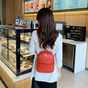 Red quilted mini backpack for women with metal handle and elegant diamond pattern embroidery