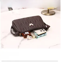 Detail view of brown quilted crossbody bag with butterfly buckle and spacious interior