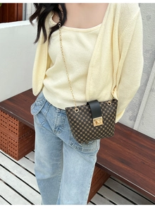 Detail of vintage monogram bucket bag with gold clasp and chain strap on a model