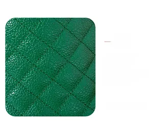 Detail of green leather bucket bag featuring diamond quilted embroidery and pebble grain texture