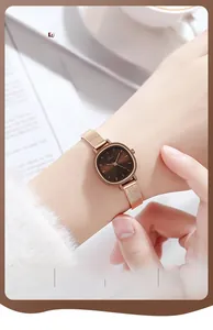 Detail of rose gold mesh strap and square brown dial quartz watch on woman's wrist