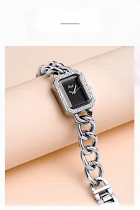 Gros plan d'une montre chaîne argentée avec lunette en strass sur support rose