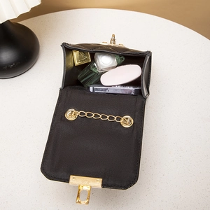 Quilted black leather crossbody bag with gold twist lock showing interior storage capacity