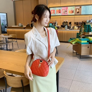 Sac bandoulière matelassé rouge pour femme avec pendentif souris dorée sur un mannequin