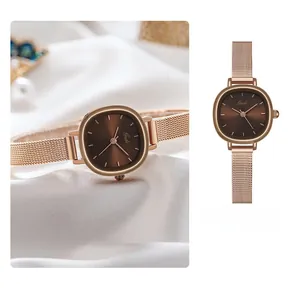 Detail of rose gold mesh strap and coffee oval dial on an elegant lady watch