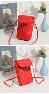 Detail of red quilted mini crossbody phone bag with horn buckle and PU leather texture