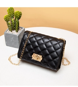 Detail of black quilted leather shoulder bag with gold chain and square twist lock