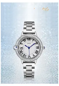 Detail of silver steel watch with rhinestone bezel, blue hands, and spinel crown
