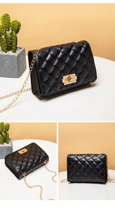 Detail of black quilted leather shoulder bag with gold chain strap and lock closure
