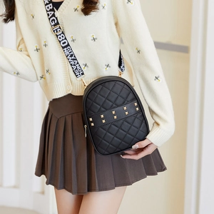 Fashion black quilted backpack with rivets and wide woven strap shown on model
