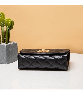 Close-up of the quilted black shoulder bag featuring a golden twist lock closure