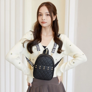 Chic black quilted backpack with gold rivets and jacquard straps shown on a model