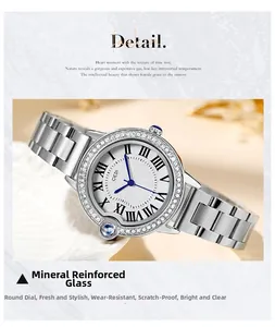 Detail of silver stainless steel watch with crystal bezel and blue hands on white dial