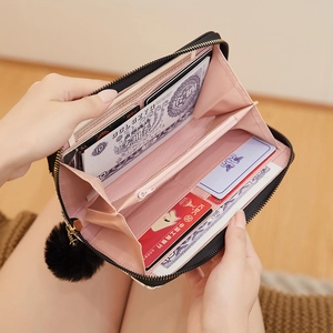 Black long zipper wallet for women with pink interior and decorative pompom charm