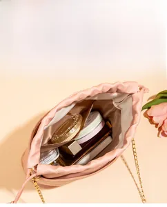 Vue intérieure du sac seau rose avec chaîne dorée montrant sa grande capacité cosmétique
