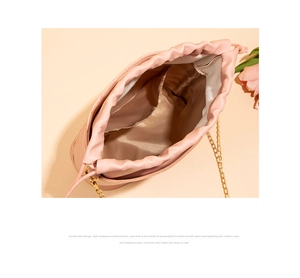 Détail du sac seau brodé rose avec chaîne dorée et fermeture à cordon coulissant