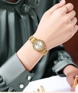 Detail of Gedi gold quartz watch with sunray dial worn on model's wrist with green dress