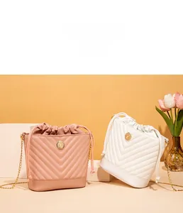 Détail de sacs seaux rose et blanc avec matelassage en V et bandoulières dorées