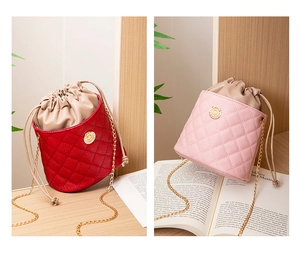 Detail view of red and pink quilted bucket bags with gold chains and drawstring lining