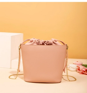 Sac seau rose à cordon en cuir PU texturé avec détail de bandoulière chaîne dorée