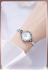 Montre à quartz argentée élégante avec cadran en nacre et cristaux au poignet