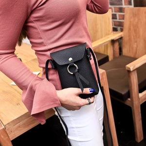 Minimalist black pebbled leather phone crossbody bag with gold ring and tassel details