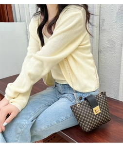 Detail of vintage round pattern crossbody bag with gold chain strap and metal lock