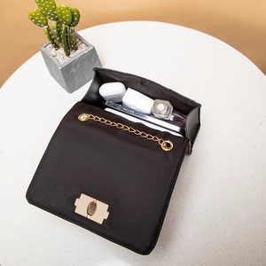 Black quilted embroidery chain bag showing inner capacity for phone and essentials